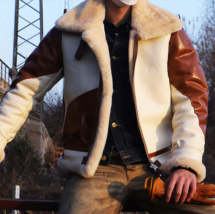 Person wearing a brown and white shearling jacket sitting outdoors.